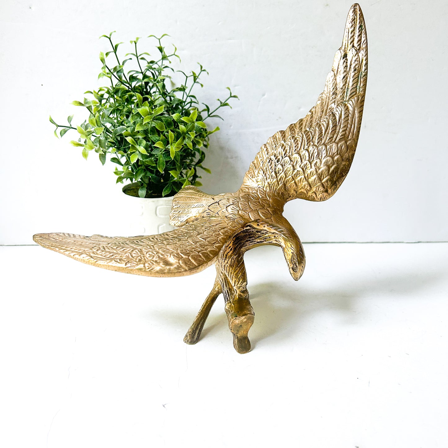 Vintage brass eagle sculpture perched on branch