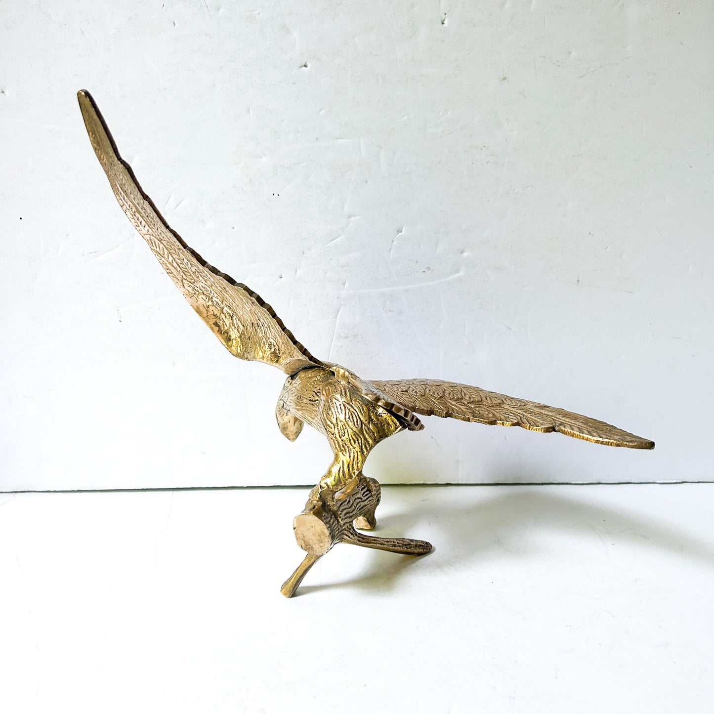 Vintage brass eagle sculpture perched on branch