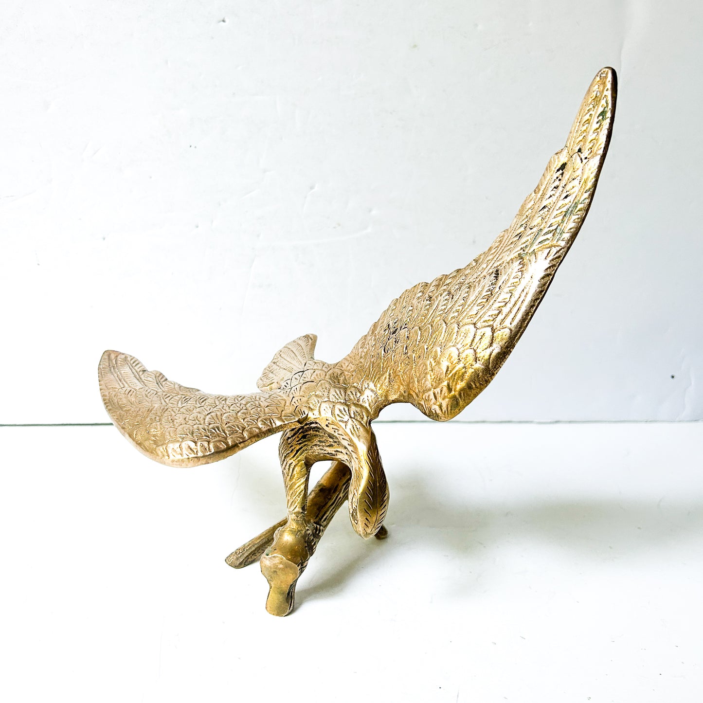 Vintage brass eagle sculpture perched on branch