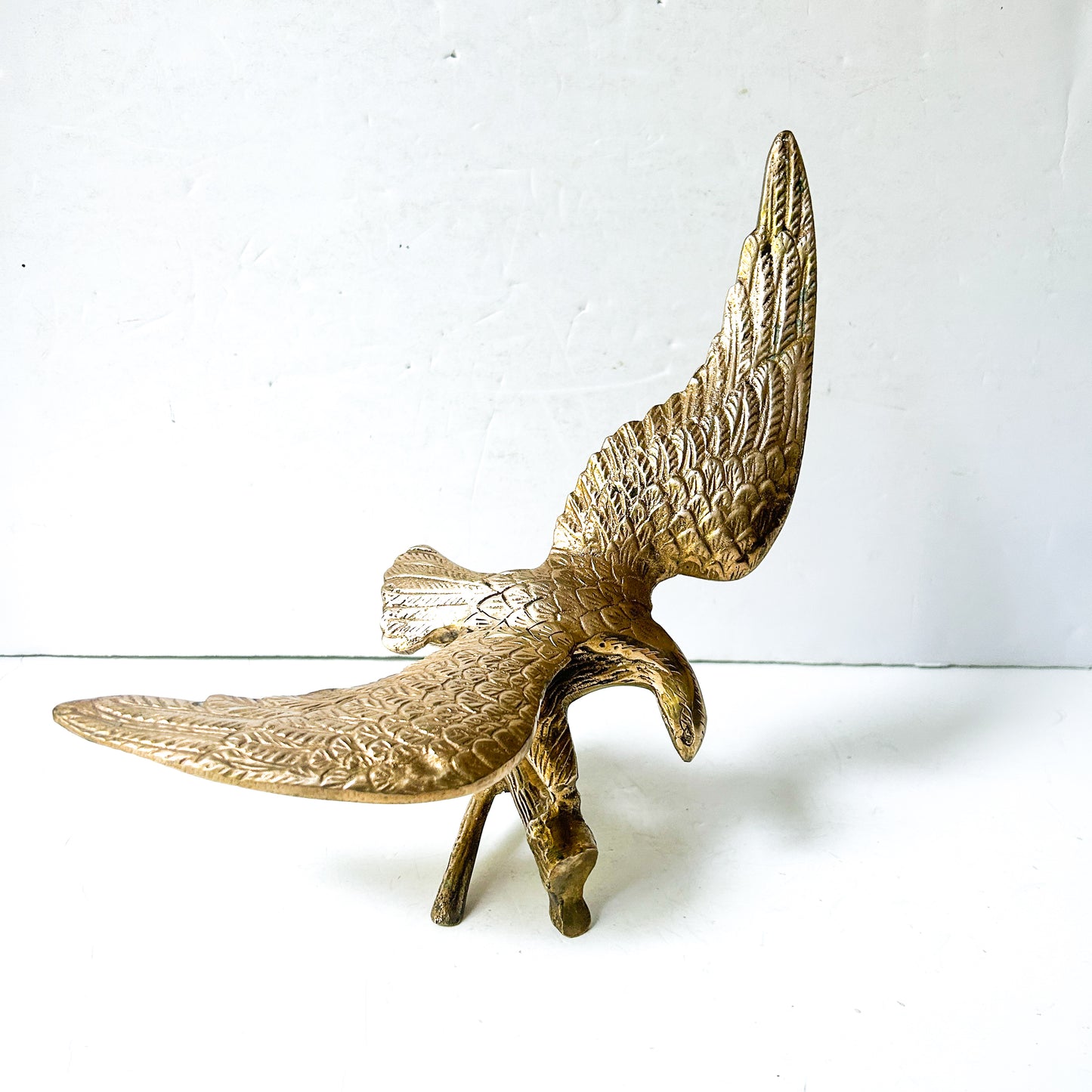 Vintage brass eagle sculpture perched on branch