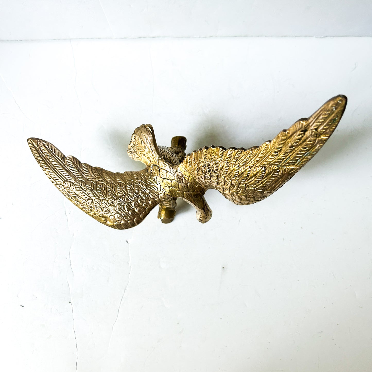 Vintage brass eagle sculpture perched on branch