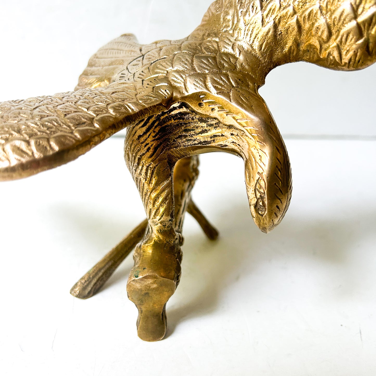 Vintage brass eagle sculpture perched on branch